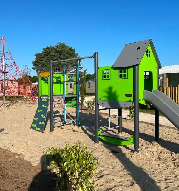 Terrain de jeux avec structure verte et toboggan.