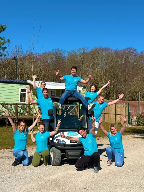 Groupe joyeux posant devant une voiturette.