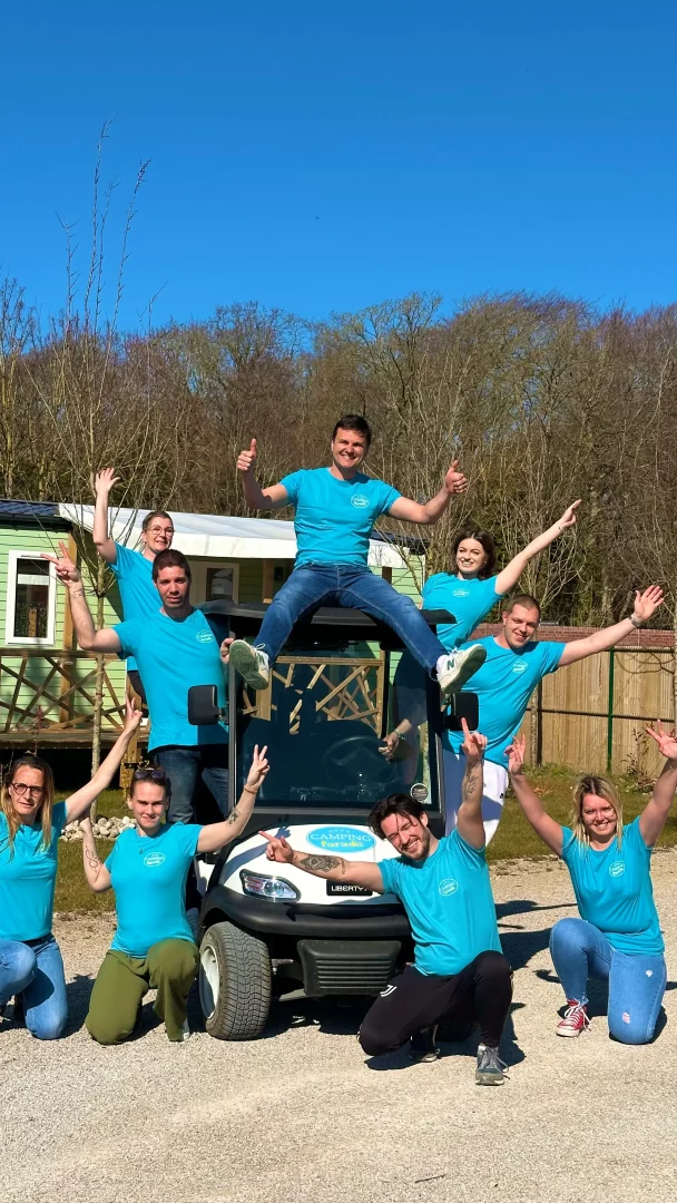 Groupe joyeux posant devant une voiturette.