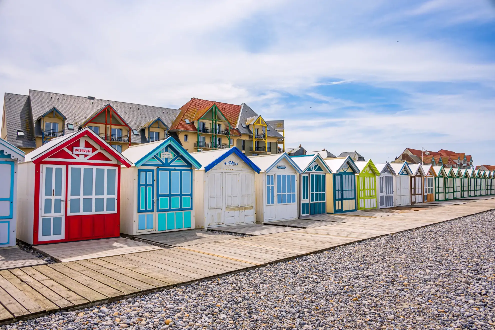 Alignement de cabines de plage colorées sur le chemin de planches de Cayeux-sur-Mer
