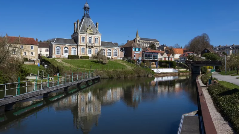 Bâtiment historique au bord d'une rivière tranquille.
