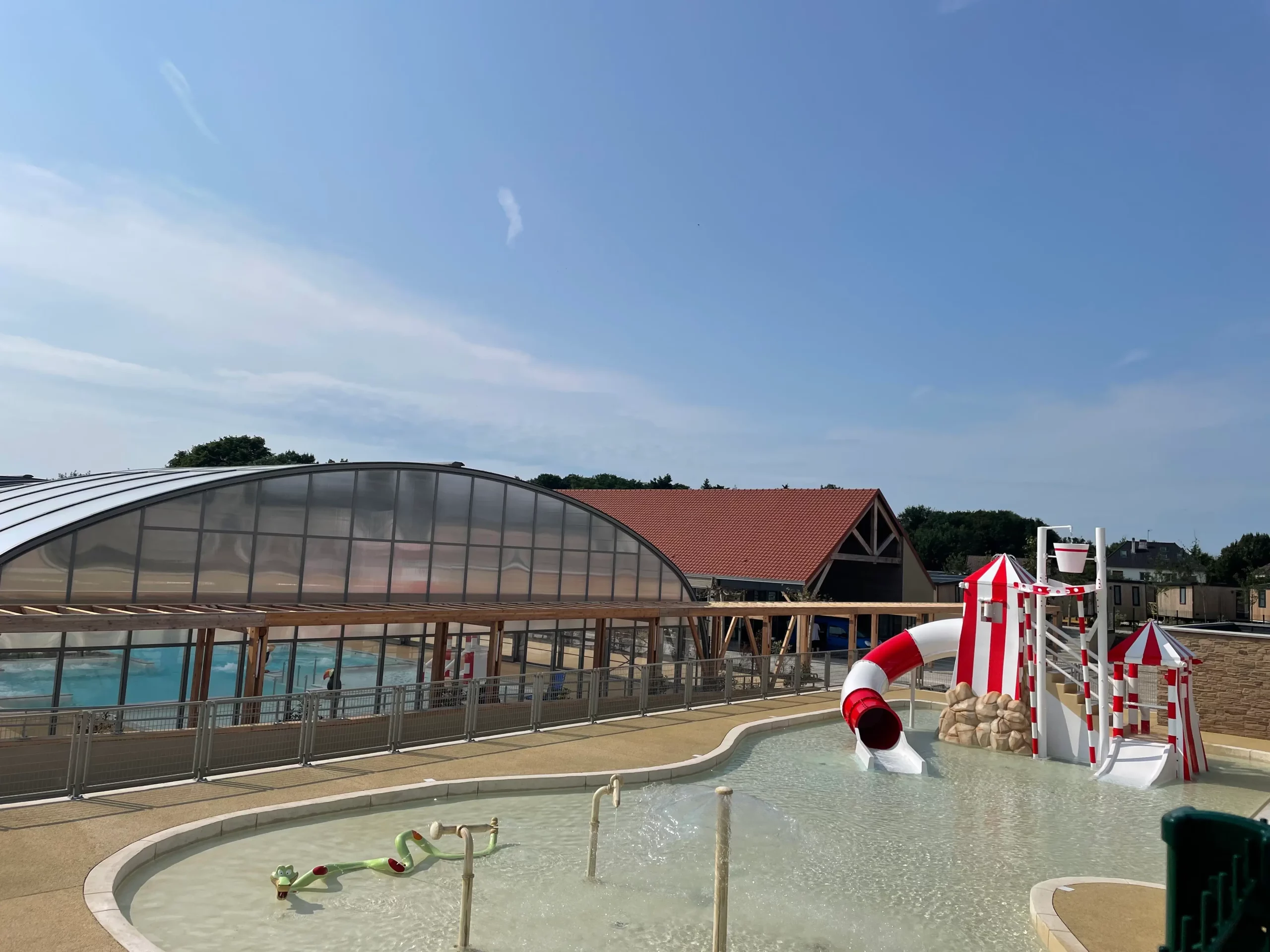 Piscine extérieure avec toboggan rouge et blanc.