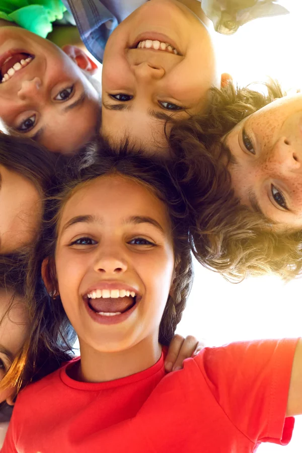 Enfants souriants réunis en cercle.