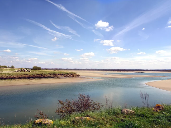 Paysage naturel avec rivière et ciel bleu.