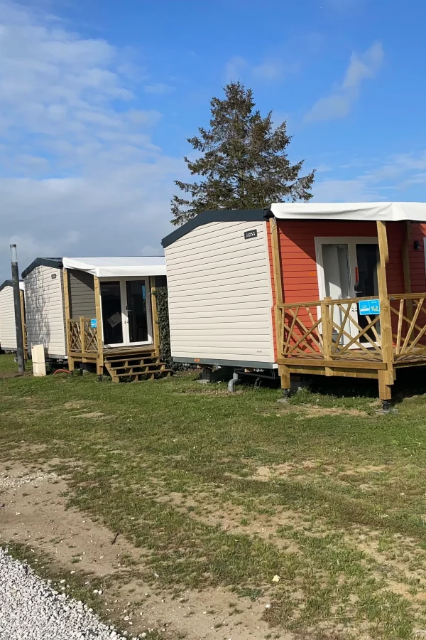Mobil-homes alignés sur un terrain herbeux.