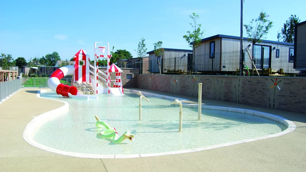 Piscine pour enfants avec toboggan et jets d'eau.
