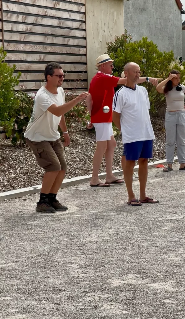 Personnes jouant à la pétanque sur un terrain.