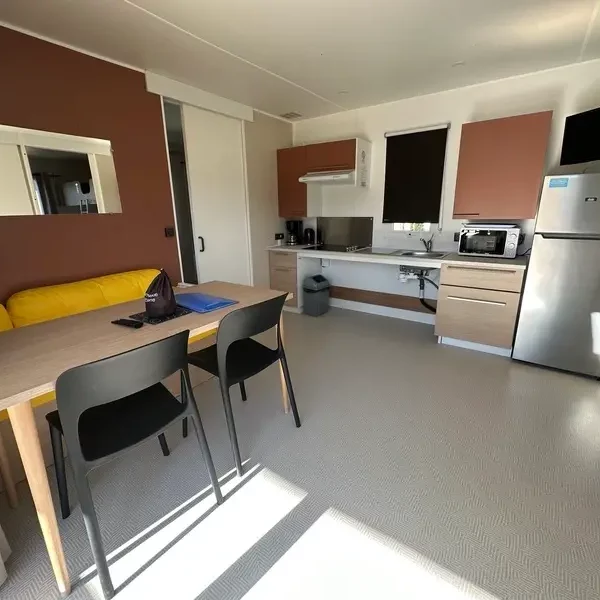 Salon avec coin repas équipé dans mobil-home de location dernière minute Baie de Somme