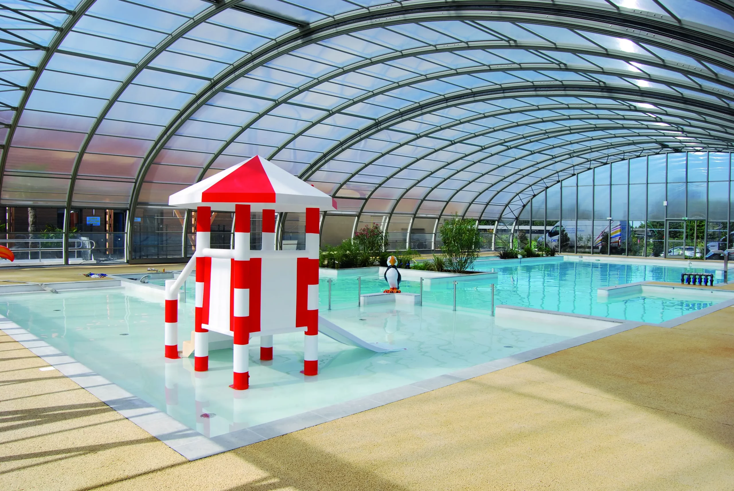 Gesichertes Planschbecken mit Mini-Rutsche und Wasserspielen für kleine Kinder auf einem Campingplatz in der Somme-Bucht.