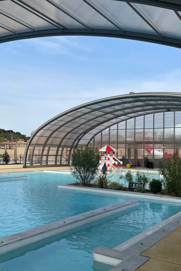 Piscine couverte avec bassin et jeux d'eau.