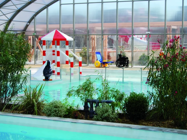 Gesichertes Planschbecken mit Mini-Rutsche und Wasserspielen für kleine Kinder auf einem Campingplatz in der Somme-Bucht.
