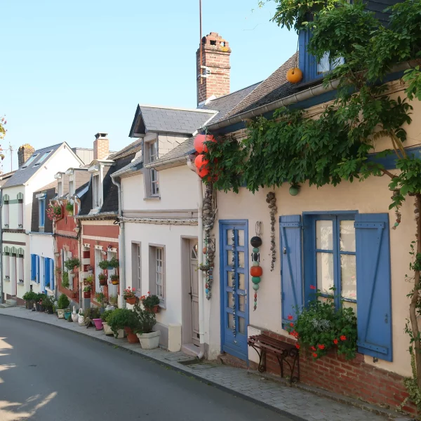 Rue pittoresque avec maisons colorées et plantes.