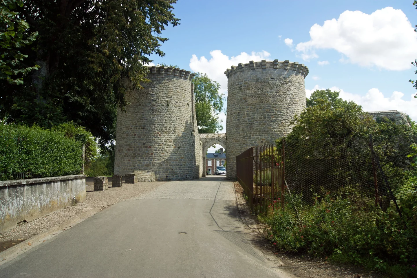 Deux tours médiévales en pierre sous ciel bleu.