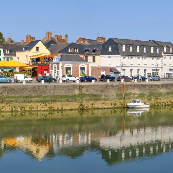 Ville côtière avec maisons et bateaux sur rivière.