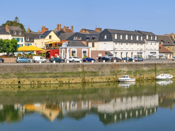 Ville côtière avec maisons et bateaux sur rivière.
