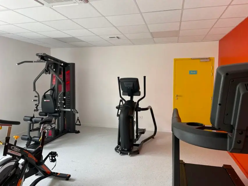 Salle de sport avec équipements de fitness modernes.