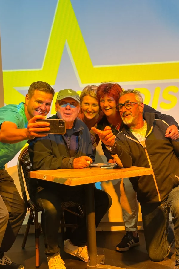 Personnes prenant un selfie à une table.