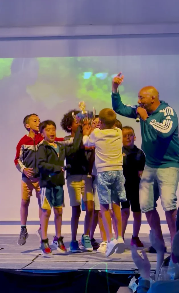 Enfants célébrant avec un trophée sur scène.