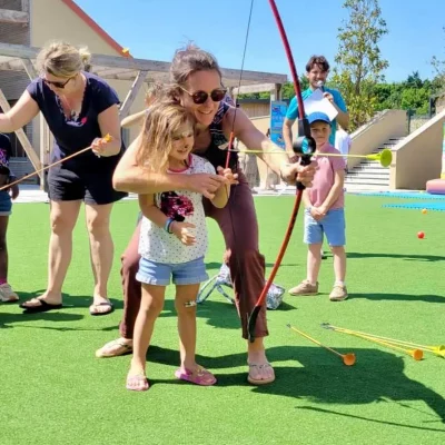 Enfants apprenant le tir à l'arc en extérieur.