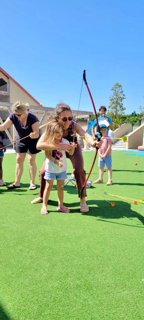 Enfants apprenant le tir à l'arc en extérieur.