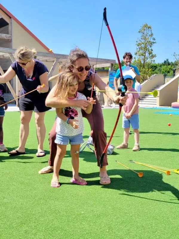 Enfants apprenant le tir à l'arc en extérieur.