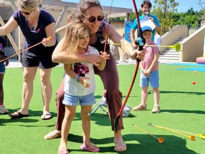 Enfants apprenant le tir à l'arc en extérieur.