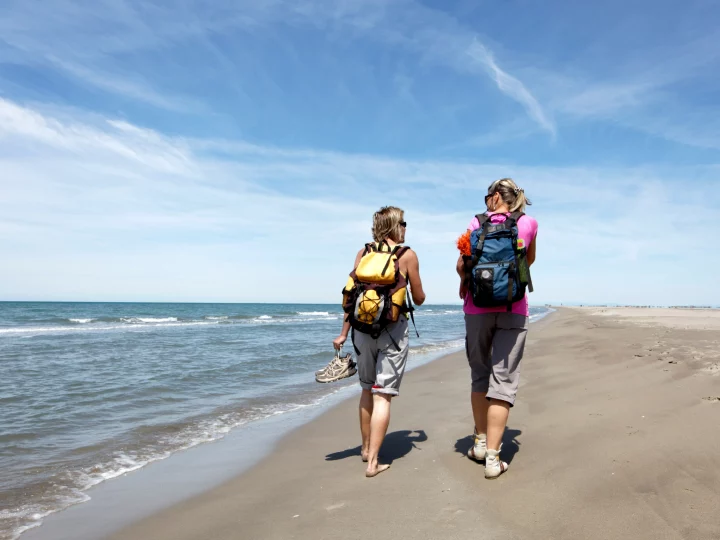 Deux randonneuses sur une plage ensoleillée.