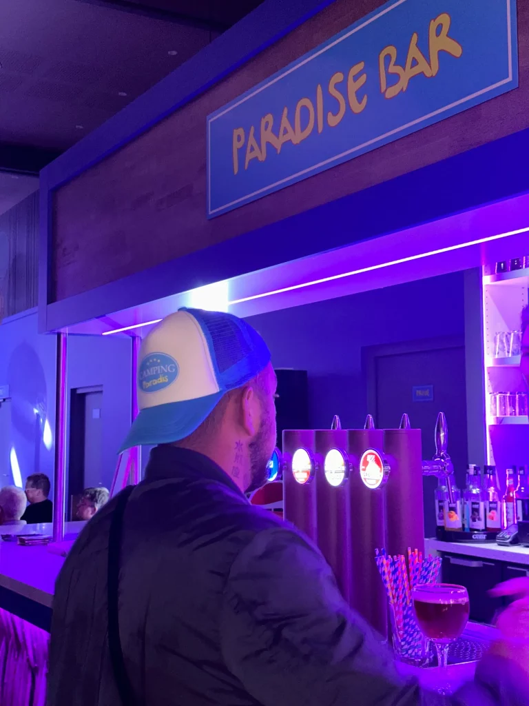 Homme au bar sous enseigne Paradise Bar