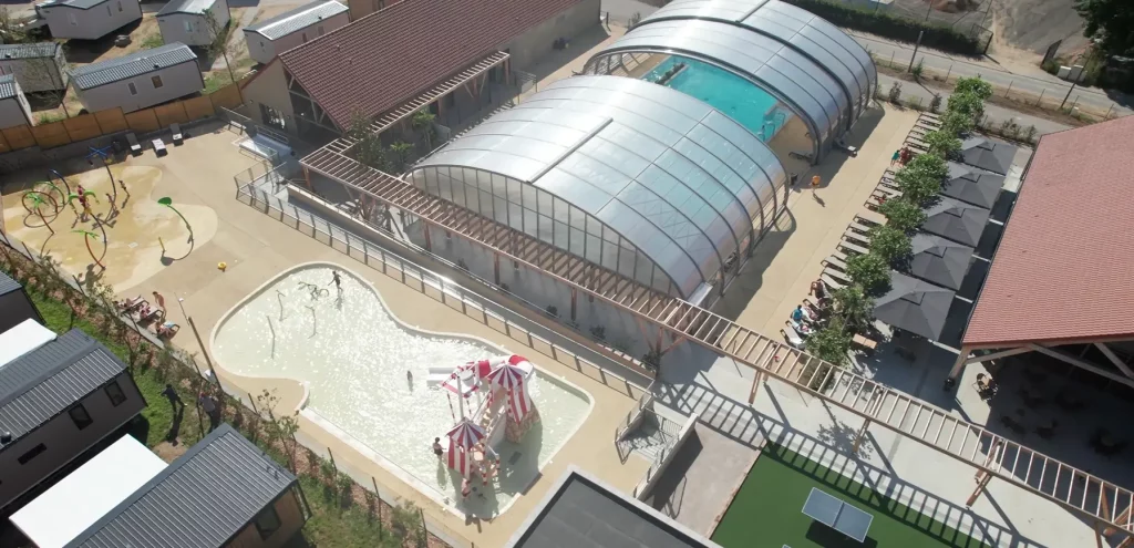 Vue aérienne piscine et aire de jeux.