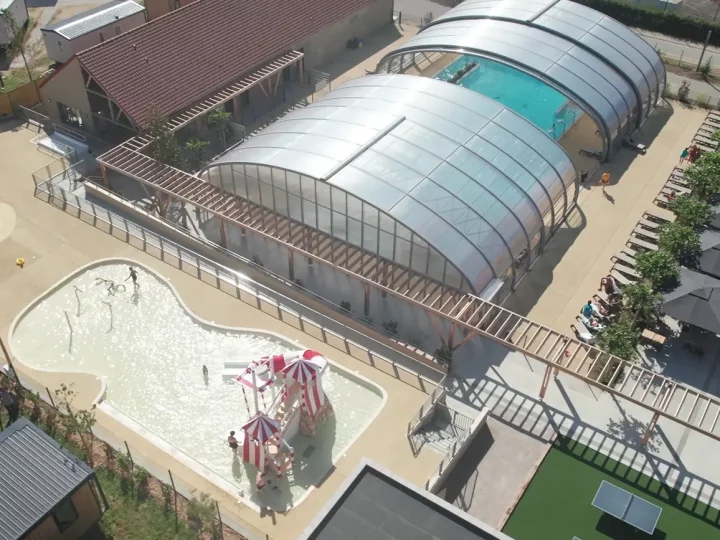 Vue aérienne piscine et aire de jeux.