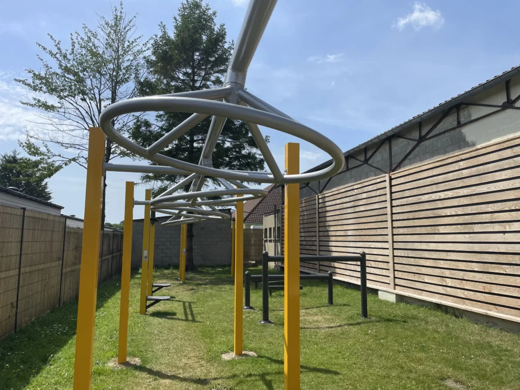 Aire de jeux extérieure avec structures métalliques.